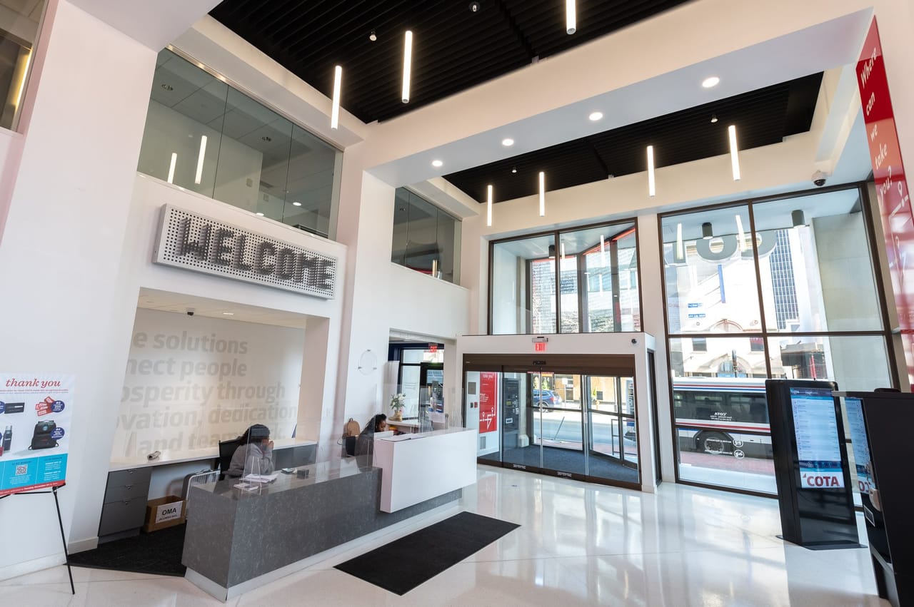 COTA lobby with a glass automatic sliding entrance and full-height storefront facing the street
